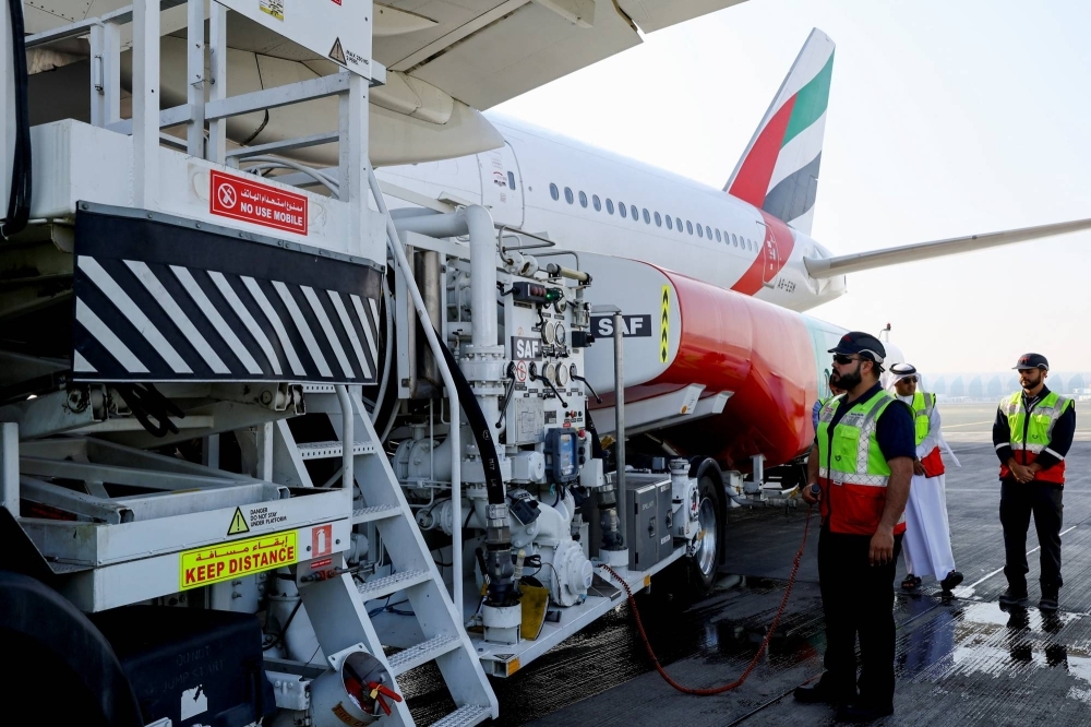 Emirates Airlines staff stand near a Boeing 777-300ER, during a demonstration running one of its engines on 100% sustainable aviation fuel in Dubai on Jan. 30.