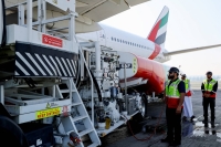 Emirates Airlines staff stand near a Boeing 777-300ER, during a demonstration running one of its engines on 100% sustainable aviation fuel in Dubai on Jan. 30. | REUTERS