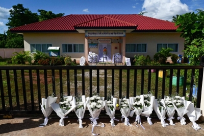 Bouquets lay against a gate leading to the nursery where one of the Thailand's worst-ever mass killings occurred in October 2022.