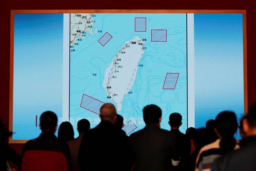 Visitors stand in front of a giant screen displaying a map of locations around Taiwan where the Chinese People's Liberation Army conducted military exercises in August 2022, at an exhibition in Beijing in October last year.