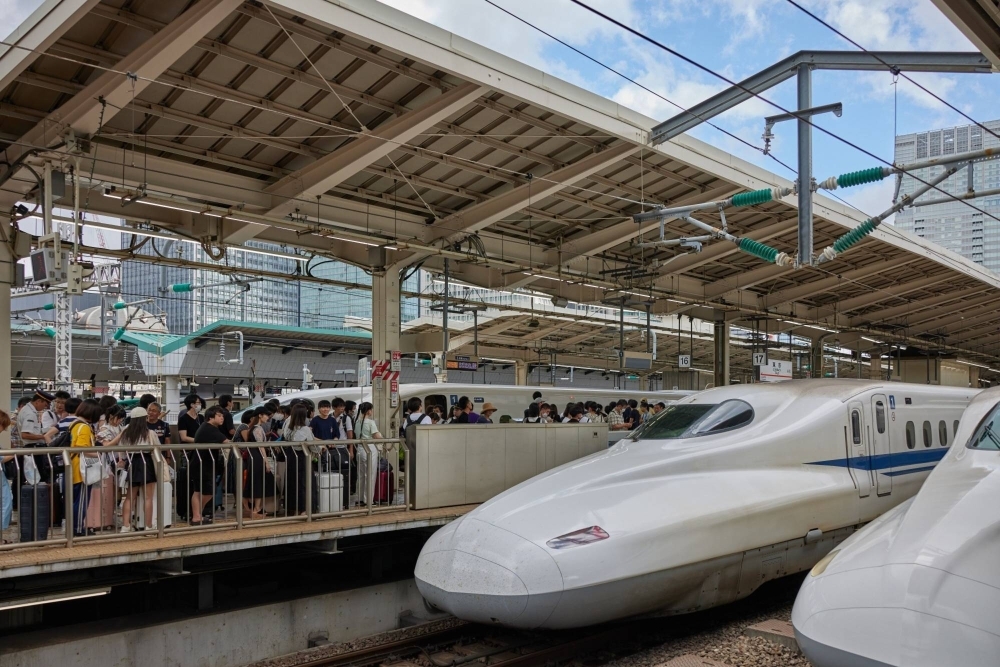 Passengers line up to board a bullet train at Tokyo Station in August.