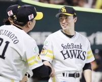 Hawks pitcher Tsuyoshi Wada (right) celebrates after picking up the win against the Eagles in Fukuoka on Tuesday. | Kyodo