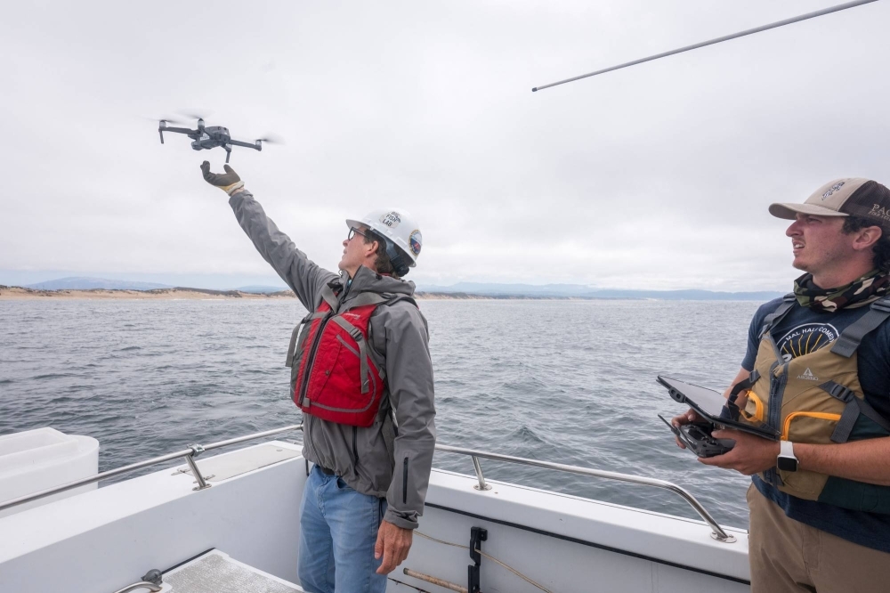 Salvador Jorgensen (left), a marine ecologist and professor at California State University, Monterey Bay, and his research assistant, Dylan Moran, use a drone to search the Monterey Bay for great white sharks near Santa Cruz, California, on Sept. 14.