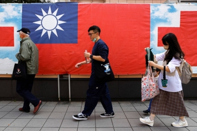 People walk past the Taiwanese flag in Taipei. Ahead of elections, Taiwan routinely flags the risk of interference from Beijing, saying that China seeks to sway the outcome to benefit candidates who may be more favorable toward the country.