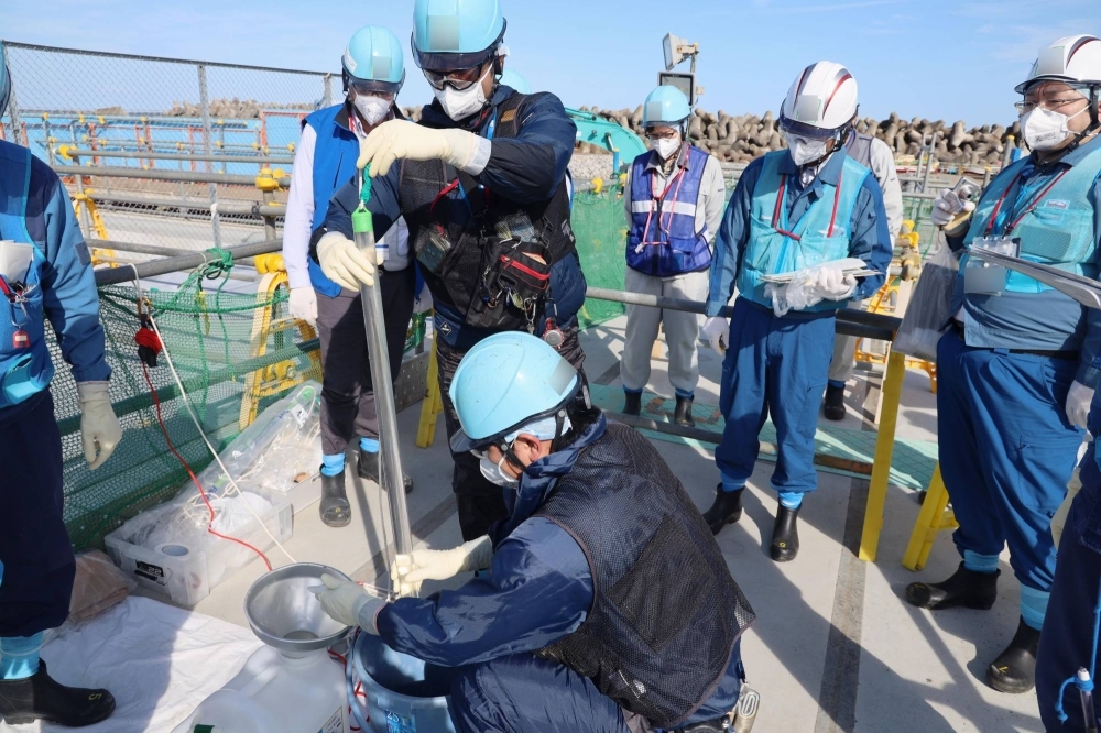 Workers check tritium levels in treated radioactive water from the Fukushima No. 1 nuclear power plant on Tuesday ahead of a water release set for Thursday.