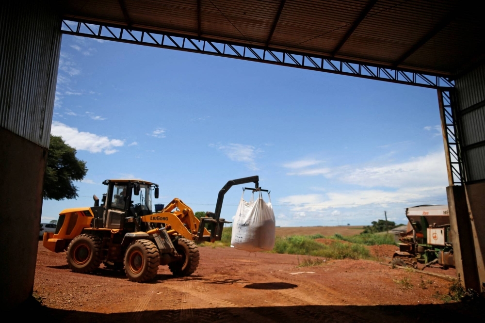 A tractor loads fertilizer before spreading it in a soybean field near Brasilia, Brazil, in February 2022.