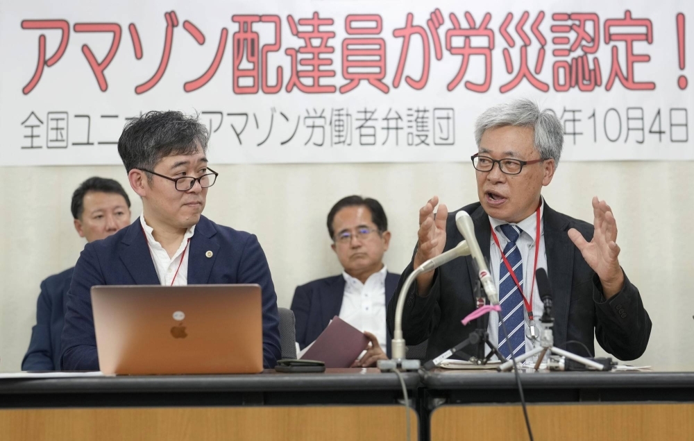 A self-employed Amazon Japan delivery driver (right) who was deemed eligible for workers' compensation holds a news conference in Tokyo on Wednesday.