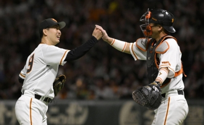 Giants pitcher Iori Yamasaki (left) celebrates with catcher Takumi Oshiro after their win over the BayStars at Tokyo Dome on Wednesday night.