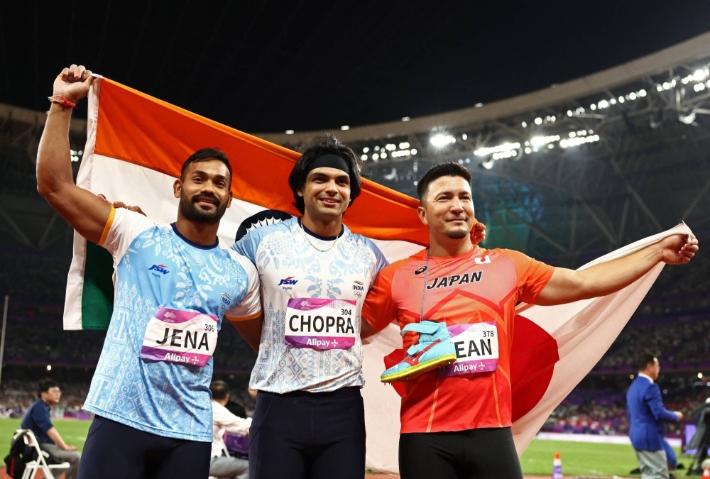 Gold medalist Neeraj Chopra (center), silver medalist Kishore Kumar Jena (left) and Roderick Genki Dean, who took bronze, pose after the men's javelin throw final at the Asian Games in Hangzhou, China, on Wednesday.