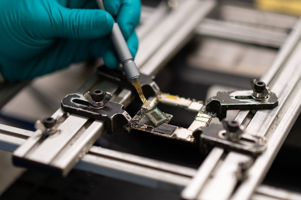 A specialist removes a Kirin 9000s chip fabricated in China by Semiconductor Manufacturing International Corp. from a Huawei Mate X5 foldable smartphone in Ottawa on Sept. 19.