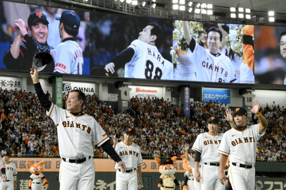 Giants manager Tatsunori Hara (left) waves to fans following his final game at Tokyo Dome on Wednesday. Shinnosuke Abe (right) will manage the team next season.