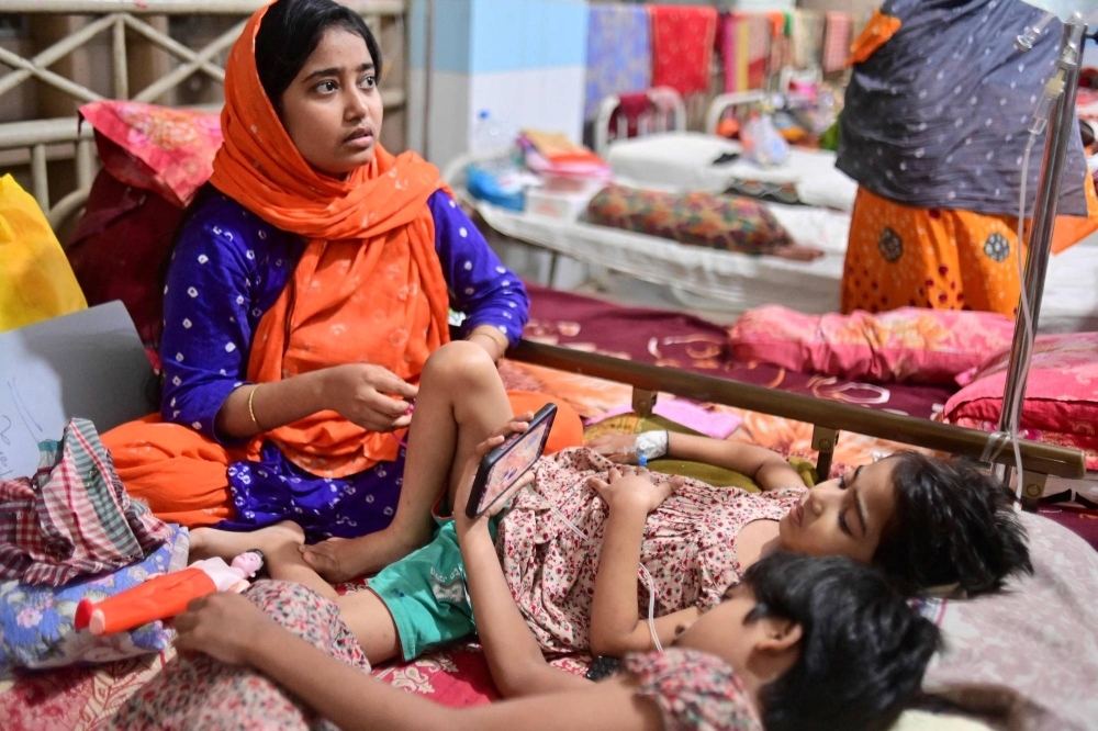 A mother sits next to her daughter while she receives treatment for dengue fever in Dhaka on Tuesday. More than 1,000 people in Bangladesh have died of dengue fever this year, the country's worst recorded outbreak of the mosquito-borne disease.