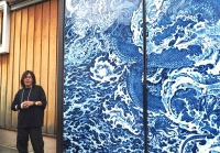 Yuki Hayama tells visitors about his dragon mural, an enlarged print of his ceramic work, showcased on the doors of the Masuda Sake Brewery. | MIO YAMADA
