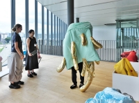 French artist Audrey Gambier (far left) observes a visitor to Go For Kogei’s “Material Imagination and Etiological Narrative: Material, Data, Fantasy” exhibition wearing one of her works at Toyama Prefectural Museum of Art and Design.  |  MASAHIRO KATANO
