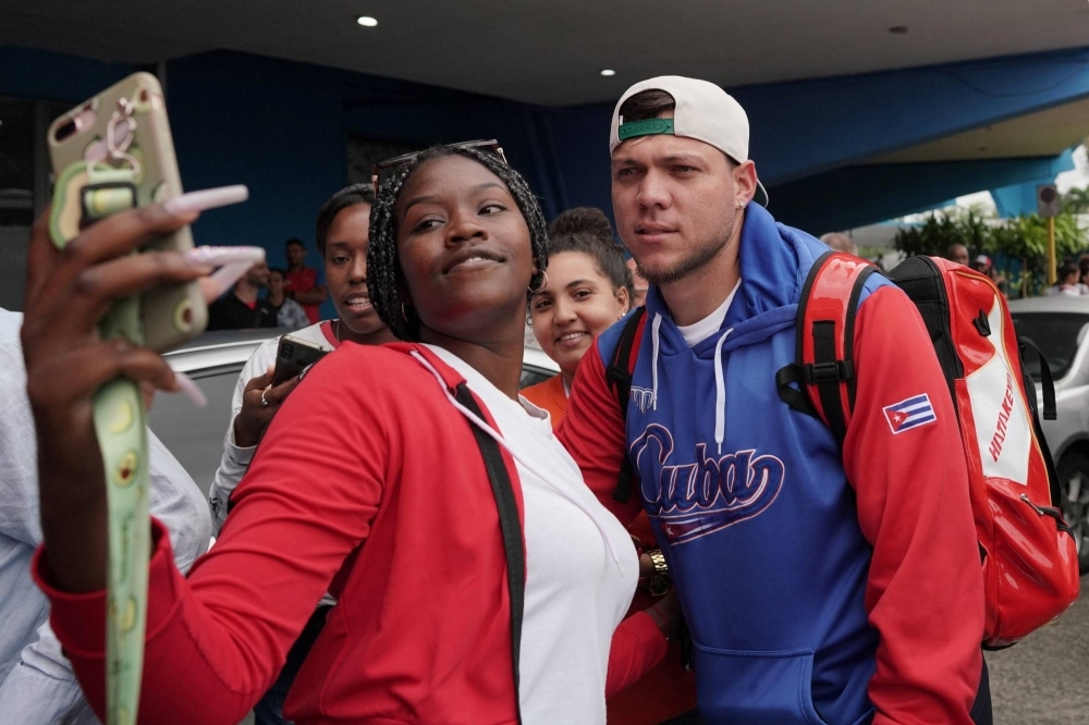 Cuban national team pitcher Yariel Rodriguez takes a photo with a fan in Havana on March 20.
