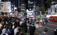 Pedestrians look on after a car plowed into a line of people in Tokyo's famous Shibuya scramble intersection Saturday evening. | KYODO