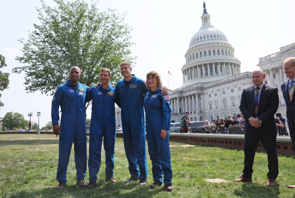 Artemis II moon mission crew members Victor Glover, Reid Wiseman, Jeremy Hansen and Christina Koch pose for photographs after taking part in a news conference with NASA Administrator Bill Nelson and U.S. Sen. Mark Kelly outside the U.S. Capitol in Washington on May 18.