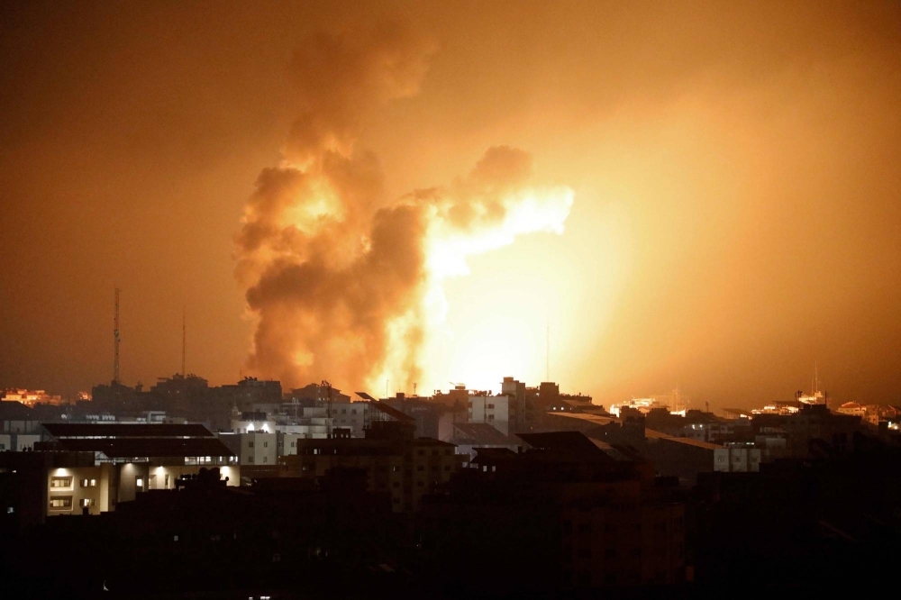 Fire and smoke rises above buildings during an Israeli airstrike in Gaza City, in the Gaza Strip, on Sunday. 