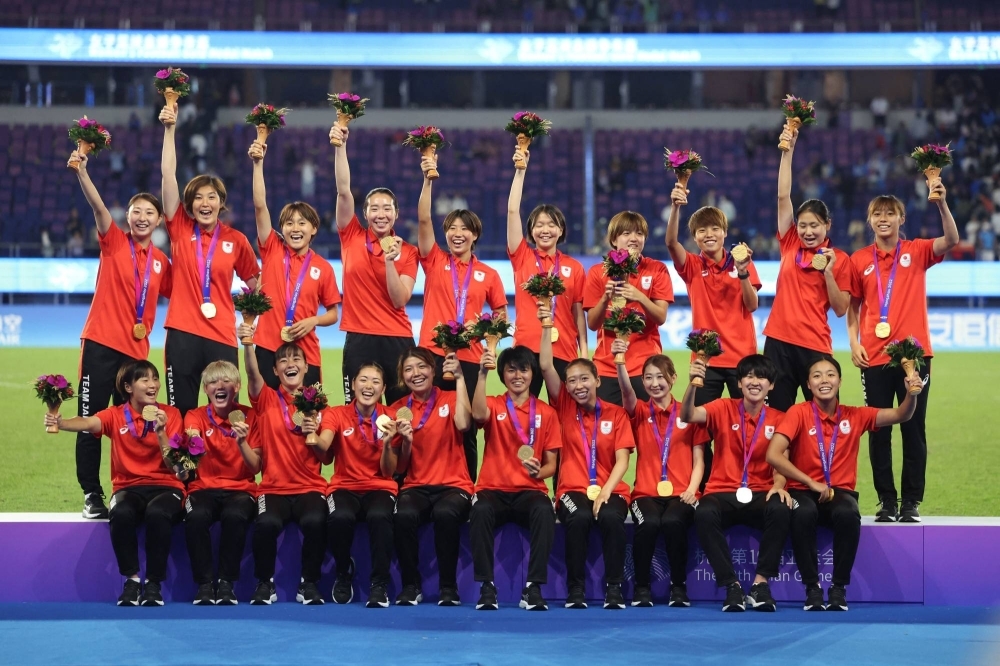 Japan's women's soccer team celebrates its Asian Games gold medal after defeating North Korea in Hangzhou, China, on Friday.