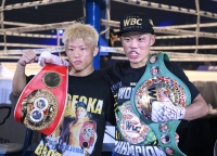 Ginjiro (left) and Yudai Shigeoka celebrate their minimumweight title wins at Ota City General Gymnasium on Saturday. | Kyodo