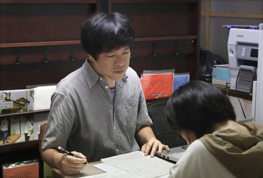 Masashi Yamaguchi teaches at the cram school he runs in Nara in August.