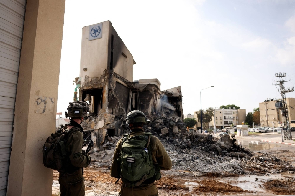 Israeli soldiers examine the remains of a police station where a battle took place following a mass infiltration by Hamas gunmen from the Gaza Strip in Sderot, Israel, on Sunday.