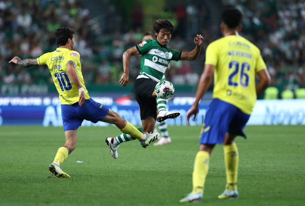 Sporting's Hidemasa Morita (center) vies for the ball during his team's match against Arouca in Lisbon on Sunday.
