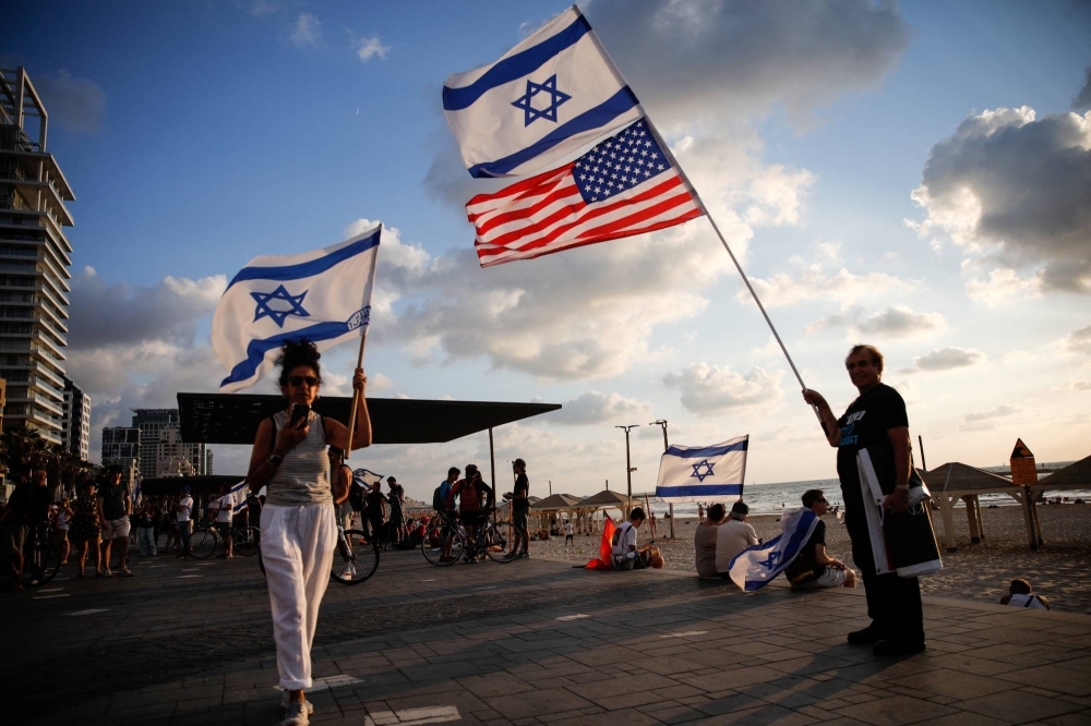 People hold Israeli and U.S. flags as they take part in a demonstration in Tel Aviv on Sept. 20.