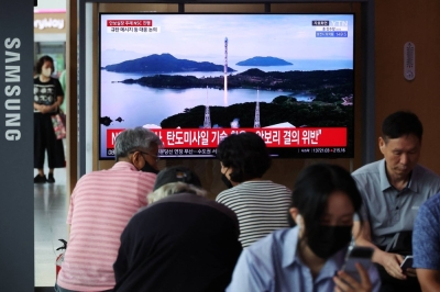 Passengers at a railway station in Seoul watch a news report on North Korea firing a space rocket, on Aug. 24.