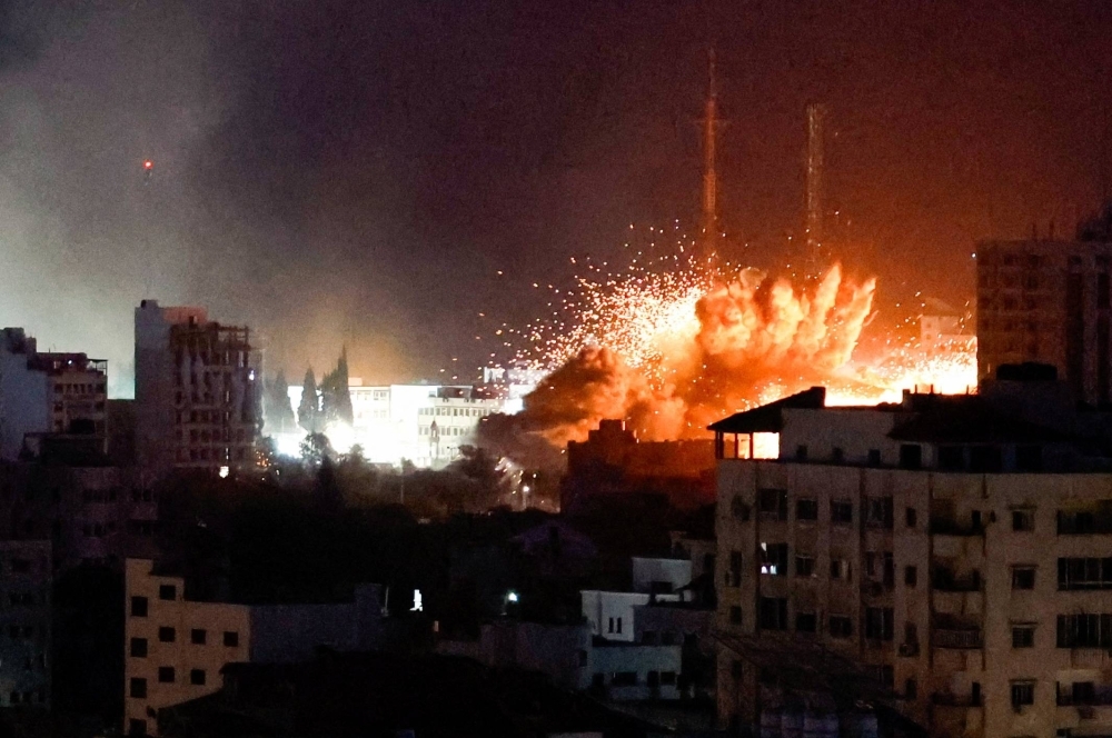 Flames and smoke billow from explosions during Israeli strikes in Gaza on Monday.