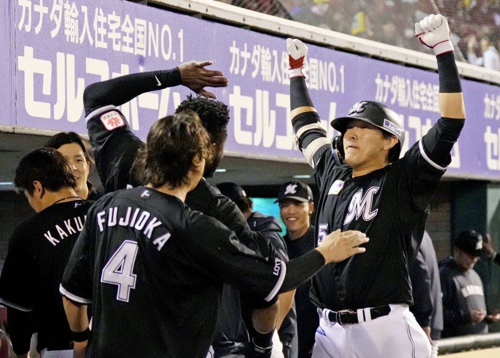 Hisanori Yasuda (right) returns to the Lotte bench after his fourth-inning solo home run against Rakuten in Sendai on Tuesday.