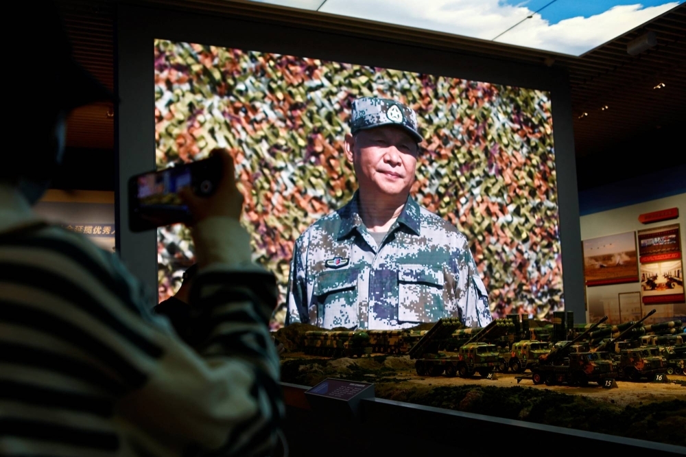 A visitor takes pictures near models of military equipment and a giant screen displaying Chinese leader Xi Jinping, at an exhibition at the Military Museum of the Chinese People's Revolution in Beijing in October last year.