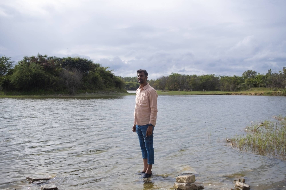 Anand Malligavad, a mechanical engineer known as “Lake Man,” stands in the clean waters of Kyalasanahalli Lake in Bengaluru, India. Malligavad, who turned to centuries-old knowledge to reclaim dozens of lakes, is now in demand across India.
