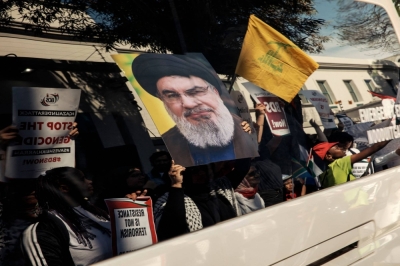 A woman holds a portrait of Hezbollah Leader Hassan Nasrallah, as South African activists shout slogans against Israel and wave Palestinian flags outside the South African Jewish Museum during a pro Palestinian demonstration in Cape Town on Wednesday.