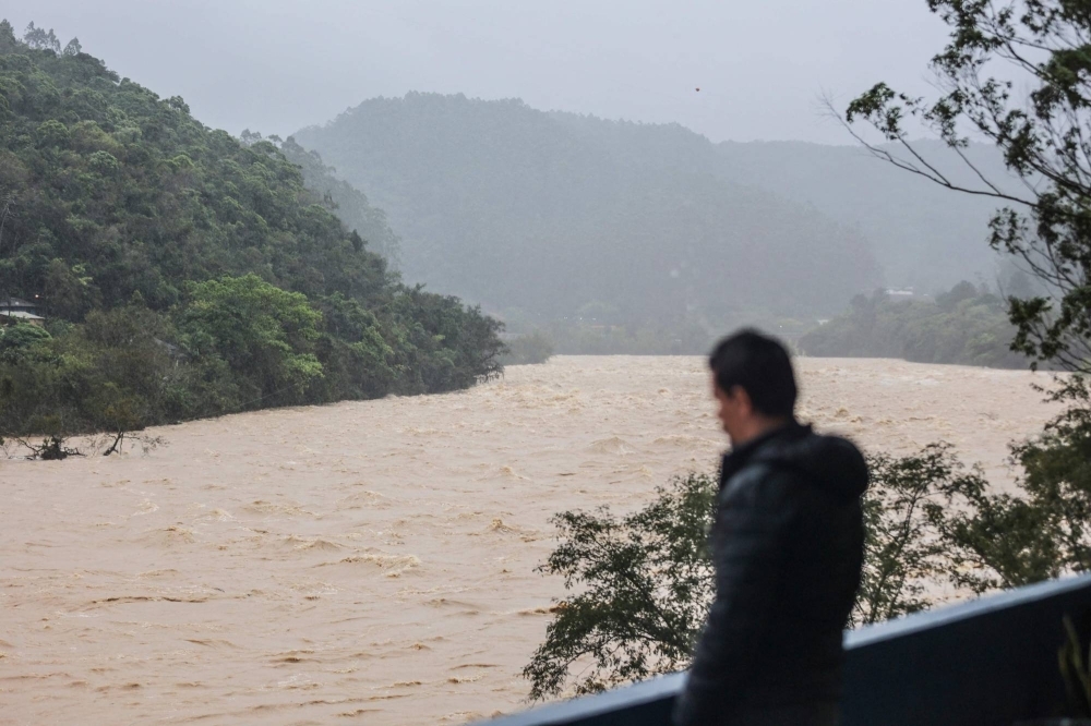 A man looks at the high water levels of the Itapicuru river due to heavy rains in the city of Ibirama, Santa Catarina State, Brazil, on Thursday.
