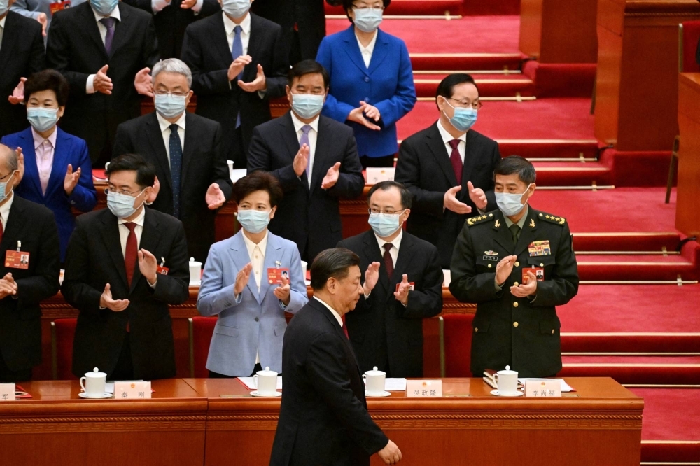 Chinese leader Xi Jinping walks past then-Foreign Minister Qin Gang (front left) and defense chief Li Shangfu (front right) as he arrives for the closing session of the National People's Congress at Beijing's Great Hall of the People in March. 