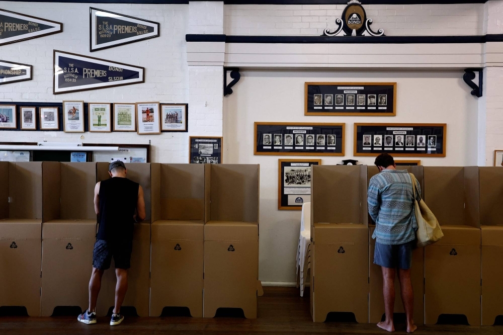 Voters fill out ballot papers at a polling station on Sydney's Bondi Beach on Saturday as polls open in Australia's historic Indigenous rights referendum.