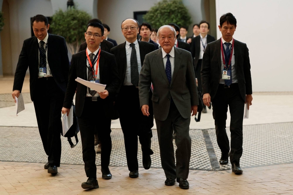 Finance Minister Shunichi Suzuki (front right) arrives for a news conference during the annual meeting of the International Monetary Fund and the World Bank, in Marrakech, Morocco, on Friday.