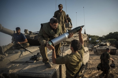 Israeli soldiers load tank shells as their unit masses in Be'eri, near the border with the Gaza Strip, on Saturday. 