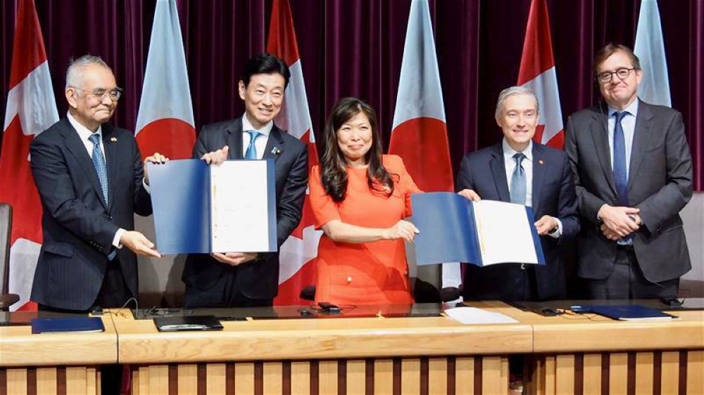 Japanese and Canadian government officials sign a memorandum of cooperation in Ottawa on Sept. 21 to strengthen electric vehicle batteries supply chains. 