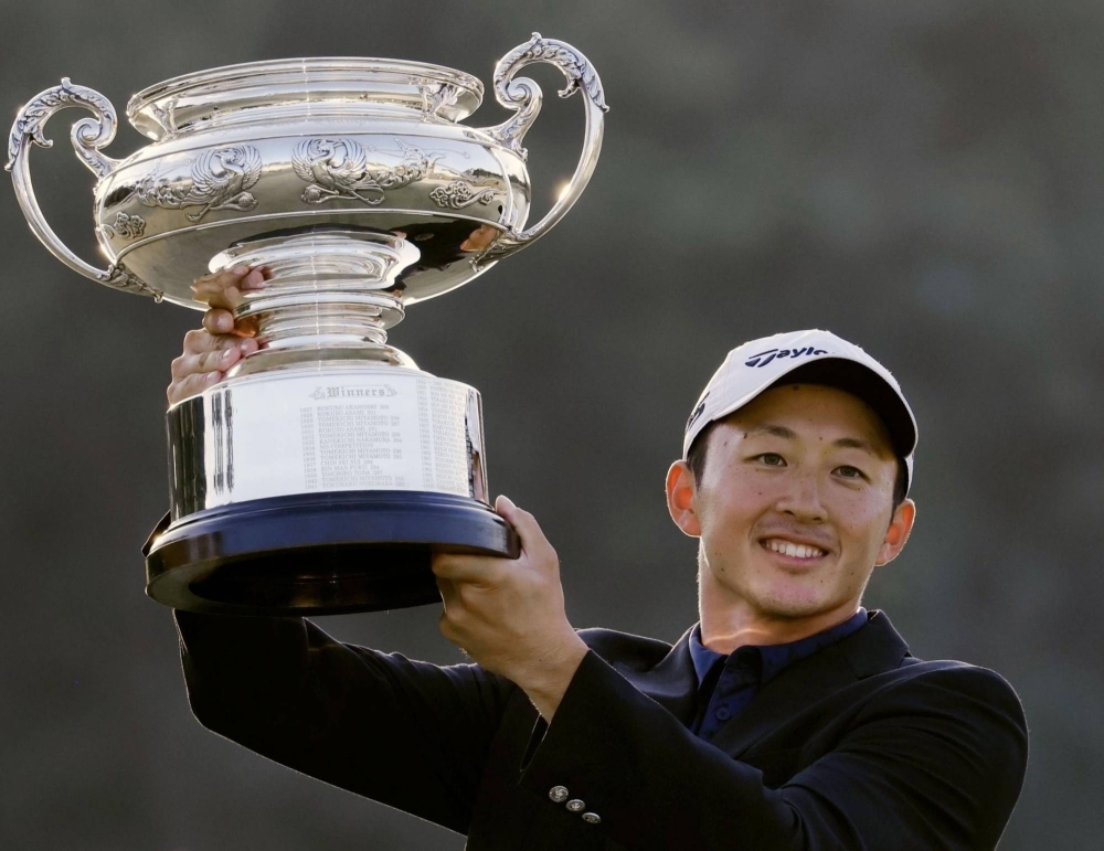 Aguri Iwasaki holds up the trophy after winning the Japan Open golf championship at Ibaraki Country Club in Ibaraki, Osaka Prefecture, on Sunday.