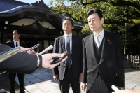 Economy minister Yasutoshi Nishimura speaks to reporters at Yasukuni Shrine in Tokyo on Monday. | Kyodo