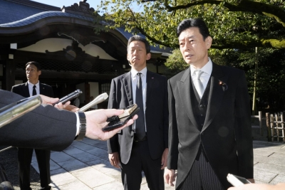 Economy minister Yasutoshi Nishimura speaks to reporters at Yasukuni Shrine in Tokyo on Monday.