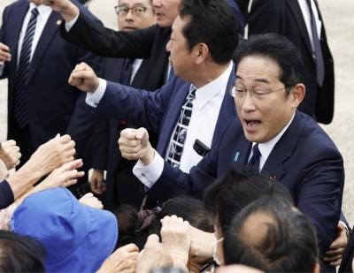 Prime Minister Fumio Kishida fist bumps voters in Sasebo, Nagasaki Prefecture, on Sunday.
