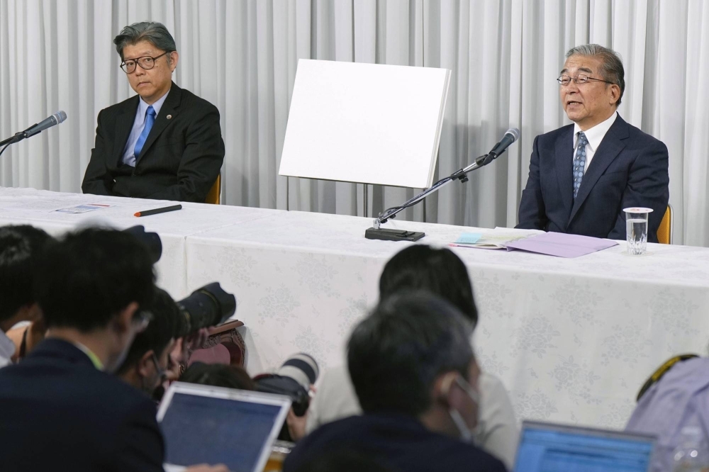 Nobuo Okamura (right), an executive handling legal affairs for the Unification Church, speaks during a news conference on Monday at the organization's headquarters in Tokyo, as the church's lawyer Nobuya Fukumoto looks on.