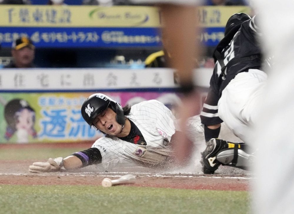 Lotte's Hiromi Oka slides home to score the winning run against SoftBank in Game 3 of the PL Climax Series first stage in Chiba on Monday.