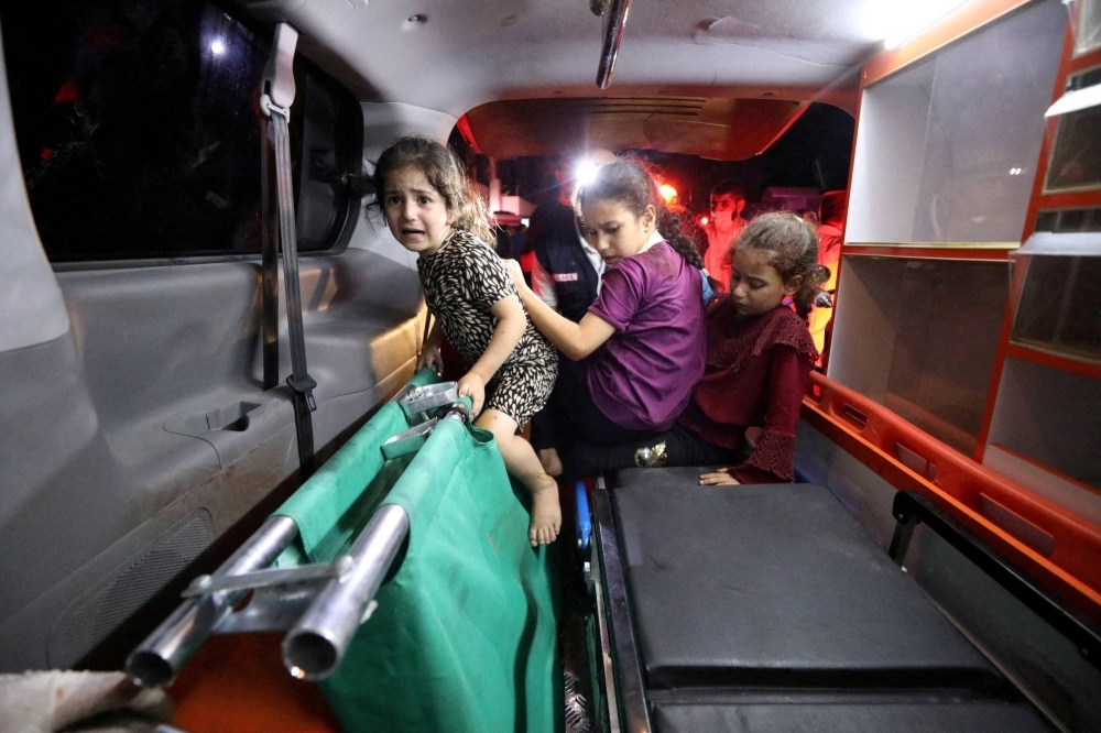 Children sit in the back of an ambulance at Shifa Hospital after hundreds of Palestinians were killed in an explosion at Al-Ahli hospital in Gaza on Tuesday. Israeli and Palestinian officials blamed on each other for the blast. 