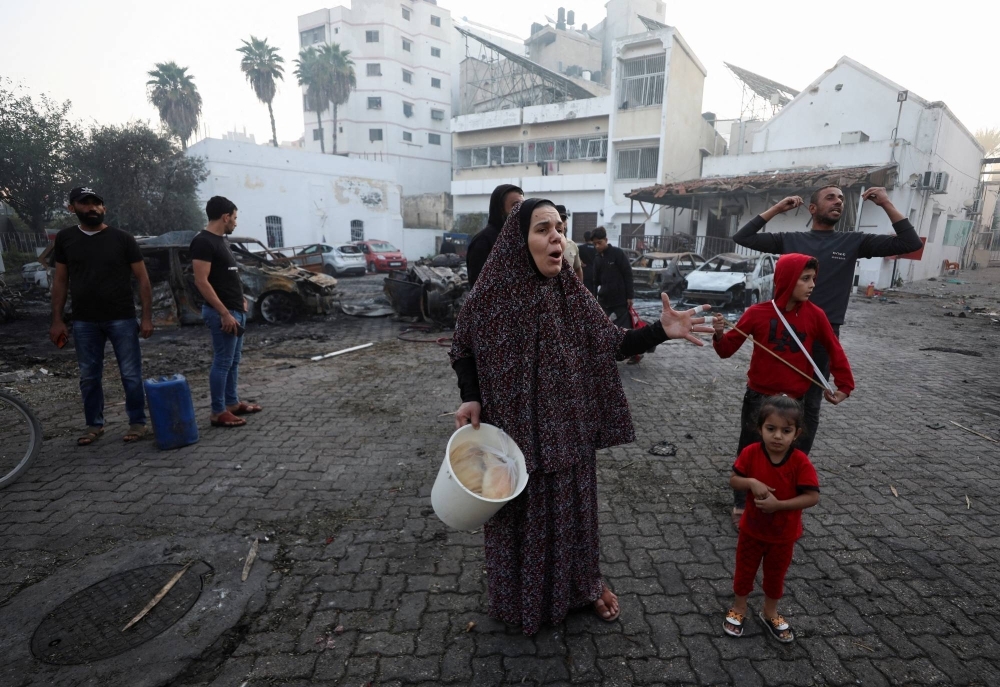 People gather on Wednesday near the al-Ahli hospital where hundreds of Palestinians were killed earlier in a blast that Israeli and Palestinian officials blame on each other.