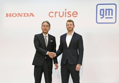 Honda CEO Toshihiro Mibe (left) and Cruise CEO Kyle Vogt shake hands in Tokyo on Thursday. 