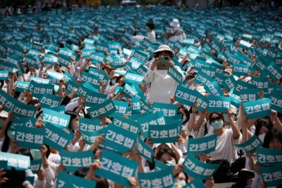 Nurses and university students majoring in nursing hold up signs that read "Nurse act", during a protest against President Yoon Suk Yeol vetoing a nursing act that defines the roles and responsibilities of nurses, in Seoul on May 19.